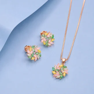 Rose gold floral pendant and earrings set featuring multicolour zircon stones displayed on a soft pastel blue background.