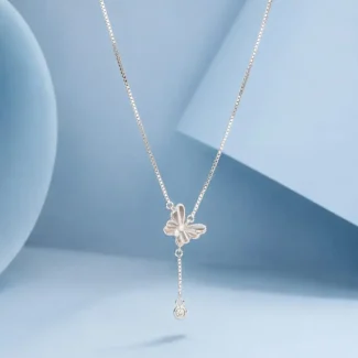 Sterling silver butterfly drop necklace with crystal charm displayed on a pastel blue background.