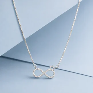Sterling silver infinity heart necklace with sparkling zircon detailing displayed on a pastel blue luxury background.
