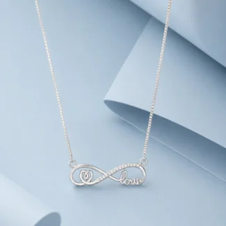 Sterling silver infinity necklace with zircon stone detailing and elegant “love” script pendant displayed on a soft pastel blue luxury background.