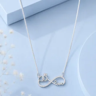 Silver infinity love pendant necklace with zircon detailing displayed on a soft pastel blue luxury background.