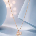 Rose gold floral pendant necklace with pearl drop and zircon accents displayed on a soft pastel blue luxury background.