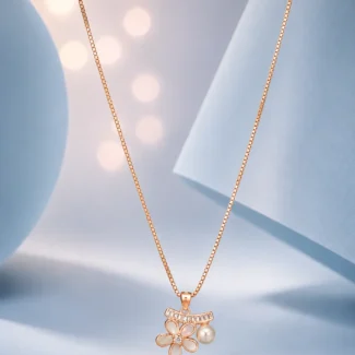 Rose gold floral pendant necklace with pearl drop and zircon accents displayed on a soft pastel blue luxury background.