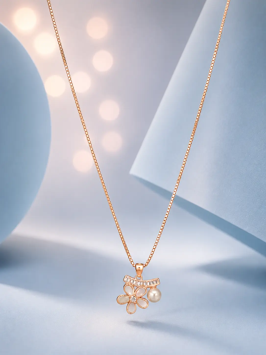 website image flower pearl rose gold Rose gold floral pendant necklace with pearl drop and zircon accents displayed on a soft pastel blue luxury background.