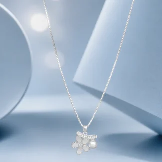 Sterling silver floral pendant necklace with pearl detail and zircon accents displayed on a pastel blue luxury background.