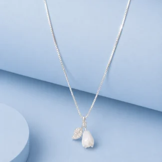 Sterling silver floral pendant necklace with white bloom charm and zircon detailing displayed on a pastel blue background