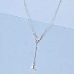 Sterling silver butterfly drop necklace with zircon detailing displayed on a soft pastel blue background.