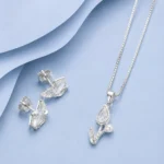 92.5 sterling silver pendant necklace with matching stud earrings featuring marquise-cut zircon stones and pearl accents displayed on a pastel blue luxury background.